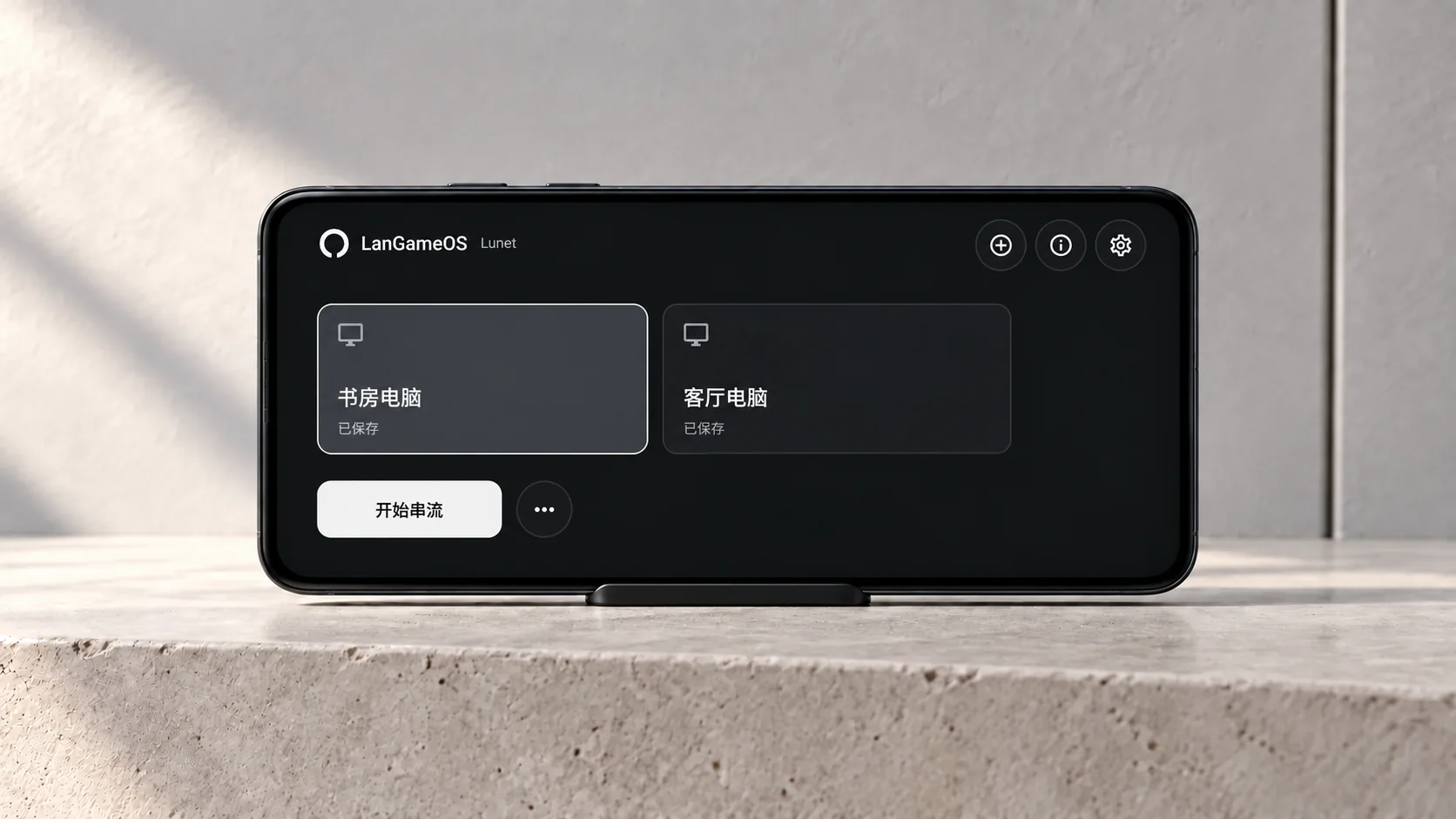 A landscape phone on a light-gray stone surface showing Lunet's updated device-selection homepage; study and living-room PCs are sample devices